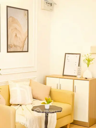 Charming living room with cozy yellow sofa, stylish decor, and elegant wall art in a bright, inviting space.