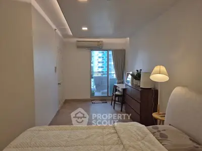 Spacious bedroom with balcony view and modern furnishings