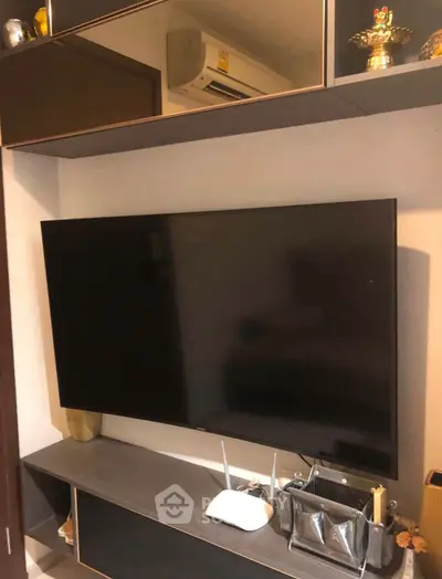 Modern living room with wall-mounted TV and sleek storage solutions.