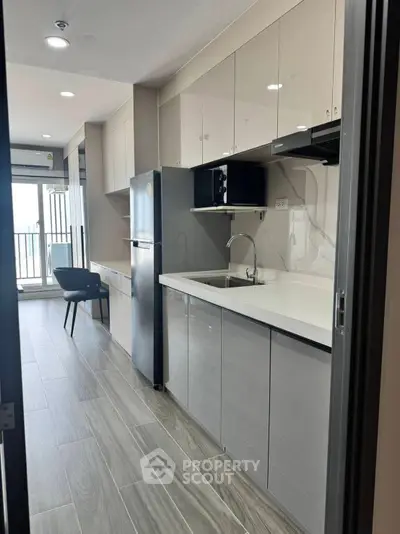 Modern kitchen with sleek cabinetry and stainless steel appliances in a stylish apartment.