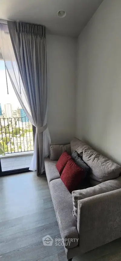 Cozy living room with plush sofa and city view balcony