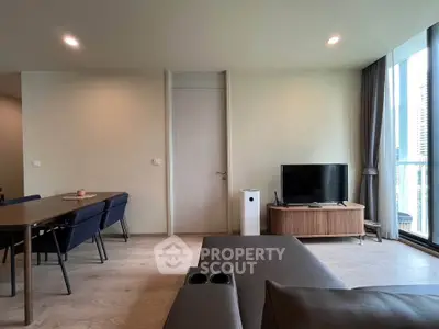Modern living room with sleek furniture and large windows offering natural light.