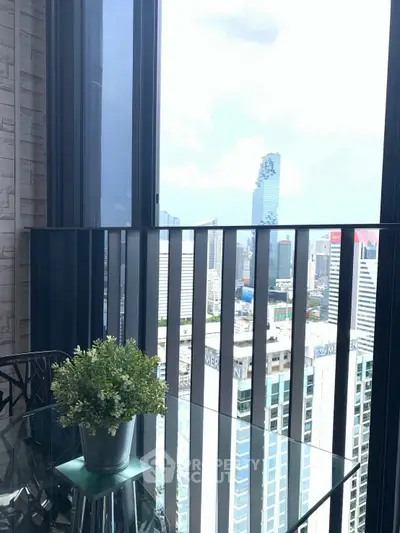 Stunning city view from a modern high-rise balcony with glass railing and potted plant.