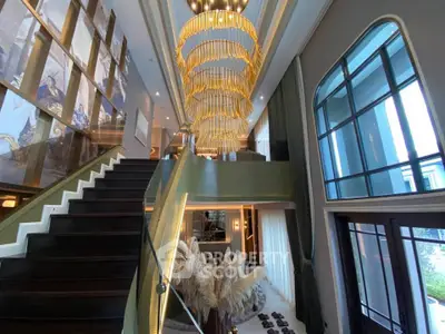 Luxurious modern living room with grand staircase and elegant chandelier