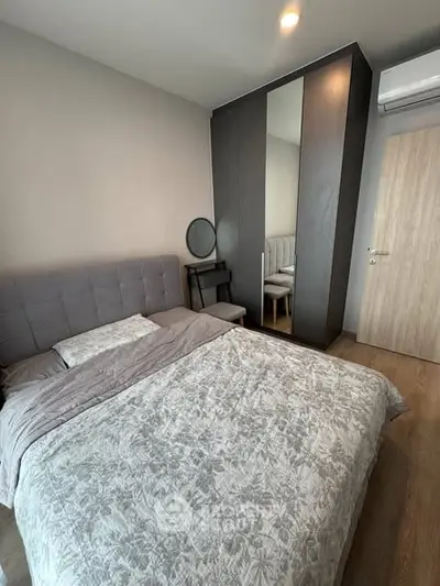 Modern bedroom with stylish decor and mirrored wardrobe in a cozy apartment.