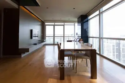 Spacious modern living room with panoramic city views and elegant dining area.