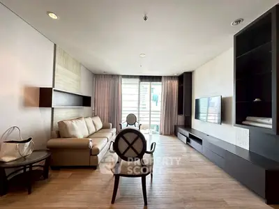Elegant living room with modern decor and natural light, featuring a comfortable sofa and stylish shelving.