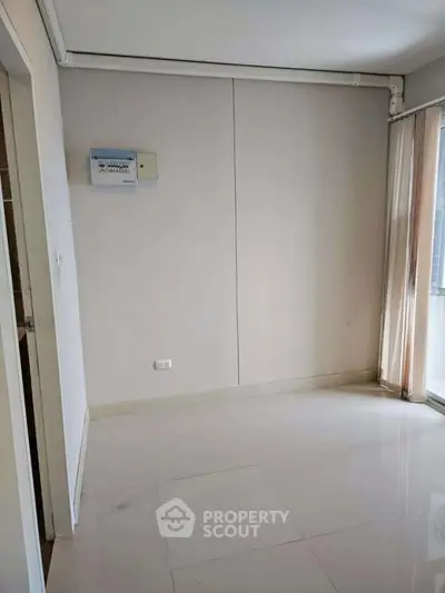 Spacious empty room with large windows and glossy tiled floor, perfect for customization.