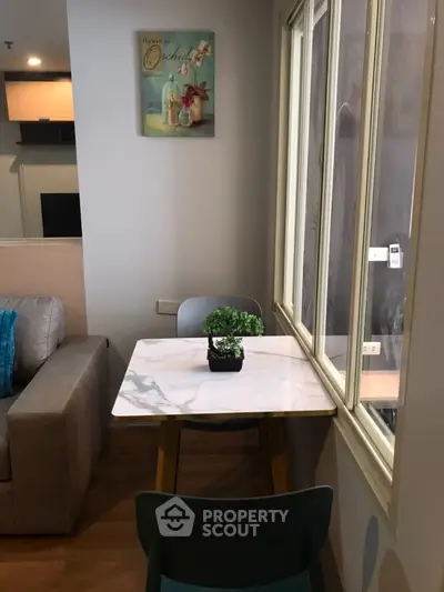 Cozy dining nook with marble table and window view in modern apartment