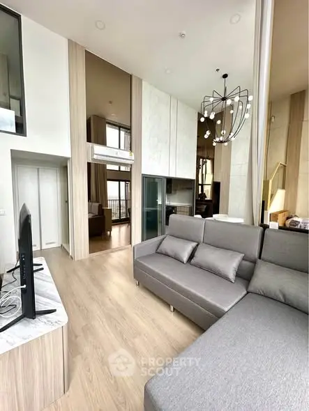 Modern living room with high ceilings and stylish decor in a luxury apartment.