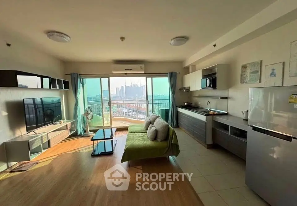 Spacious modern living room with open kitchen and city view, featuring stylish decor and ample natural light.