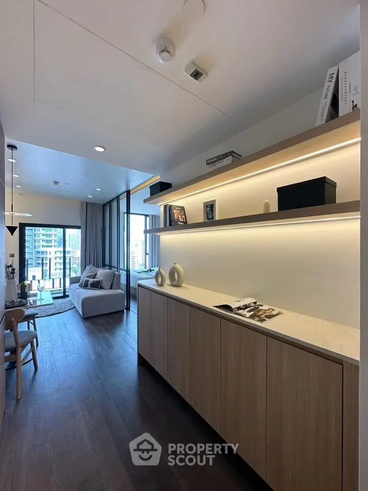 Modern living room with sleek design and city view, featuring elegant shelving and cozy seating area.