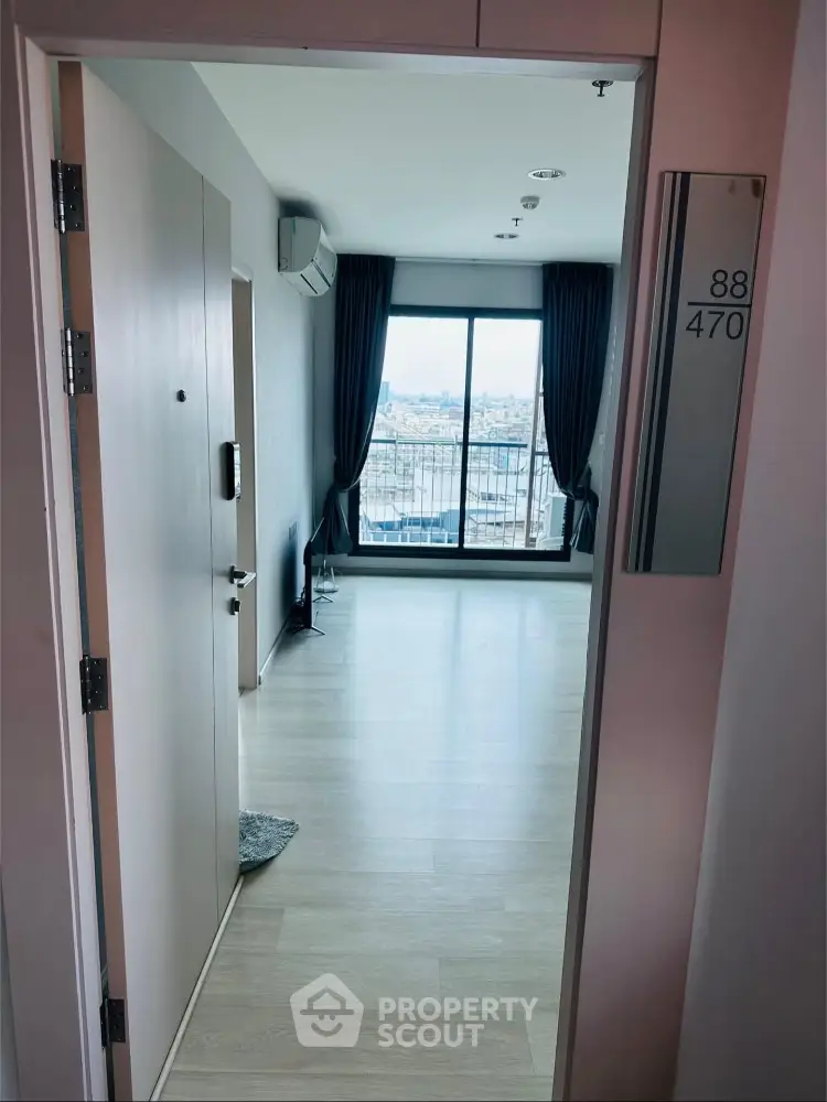 Spacious apartment entrance with large windows and city view