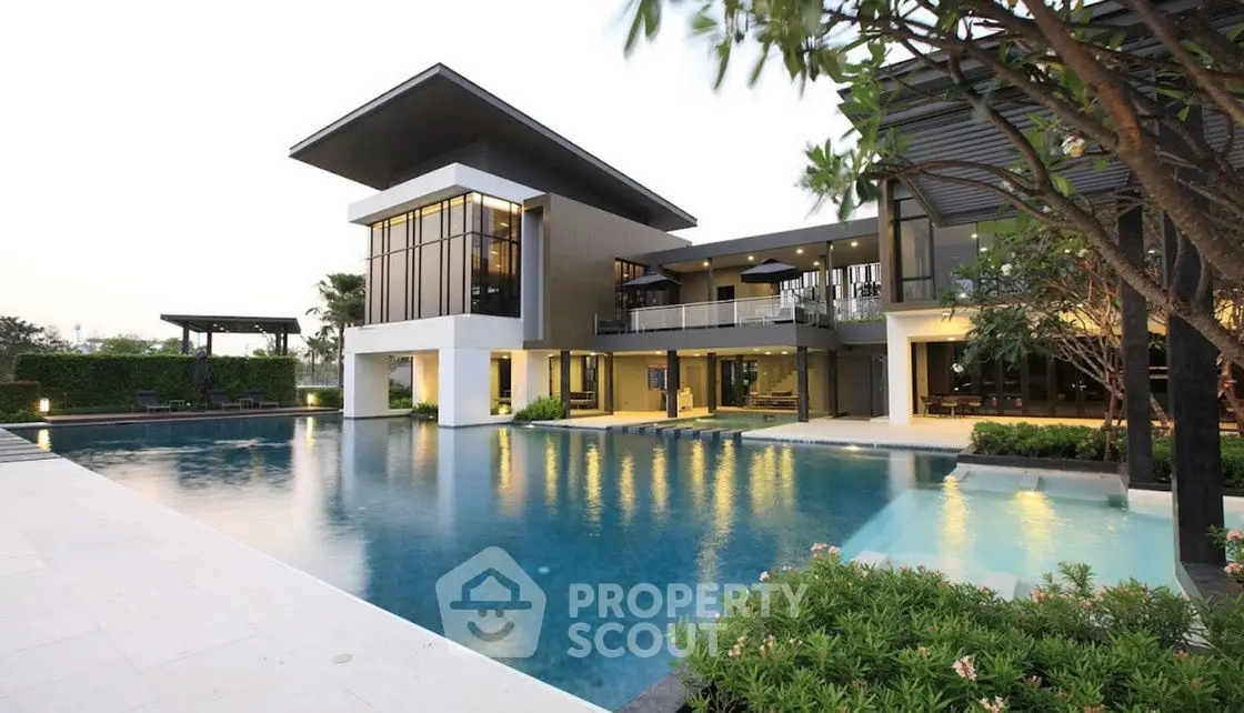 Luxurious modern villa with expansive pool and lush garden, showcasing stunning architectural design.