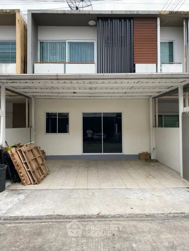 Spacious modern townhouse with covered parking and a sleek facade, featuring large windows and a balcony, ideal for urban living.