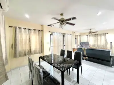 Spacious living room with elegant dining set and ceiling fans, perfect for family gatherings.