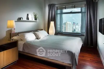 Spacious bedroom with city view and elegant decor in modern apartment.