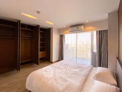 Spacious bedroom with open closet and large window view