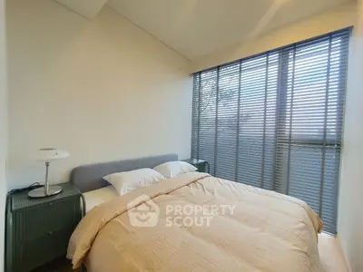 Cozy bedroom with large windows and modern decor, perfect for relaxation and comfort.