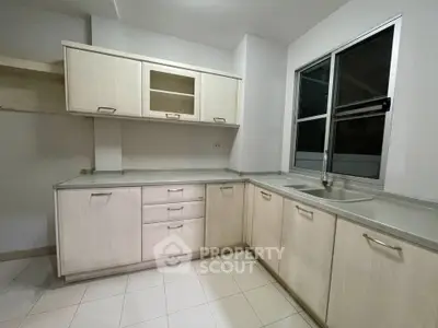 Modern kitchen with sleek cabinetry and large window for natural light.