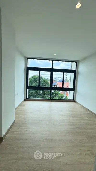 Spacious room with large window offering stunning views and natural light.