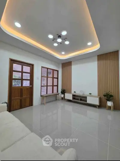 Modern living room with stylish ceiling lights and wooden accents, perfect for contemporary living.