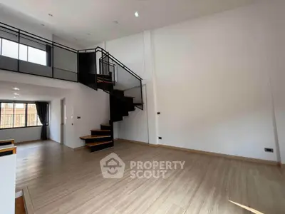Spacious modern living room with sleek staircase and large windows