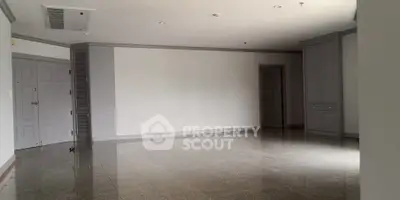 Spacious empty room with glossy flooring and neutral walls, ideal for customization.