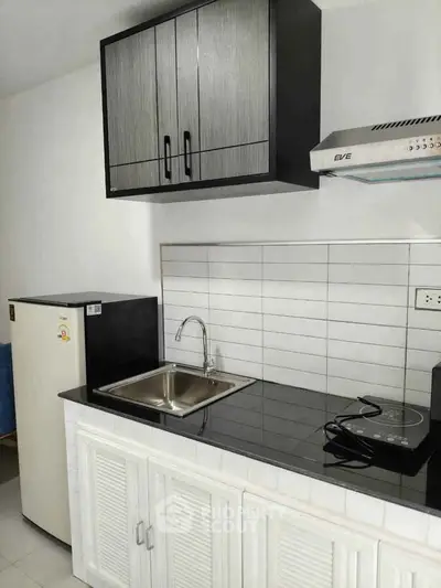 Modern kitchen with sleek black countertops and compact appliances, perfect for urban living.