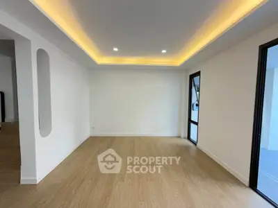Spacious modern living room with elegant recessed lighting and wooden flooring