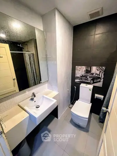 Modern bathroom with sleek fixtures and stylish decor, featuring a unique wall art piece.