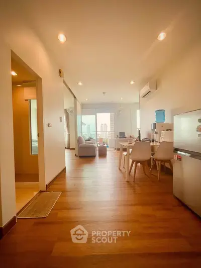 Spacious open-plan living room with modern decor and city view.