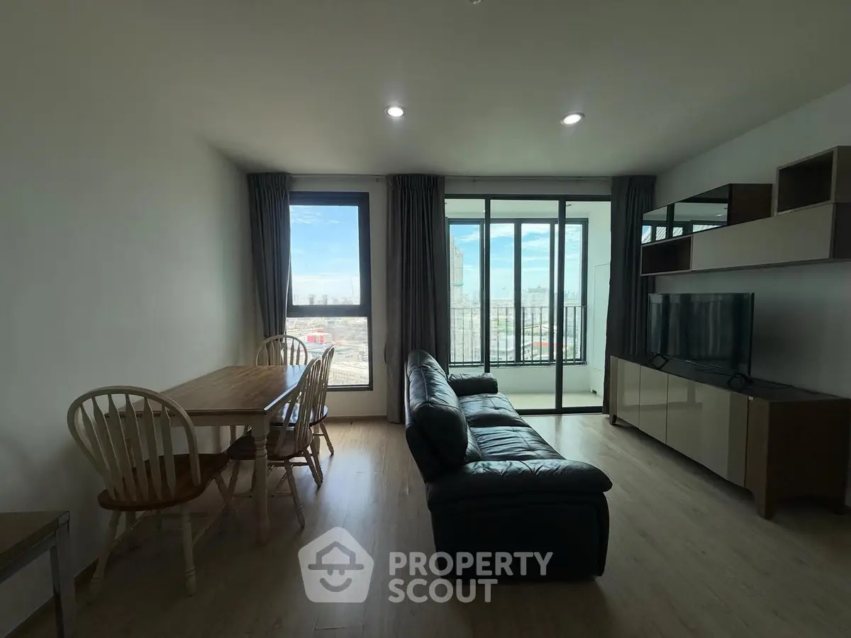 Spacious living room with modern furniture and city view, perfect for urban living.