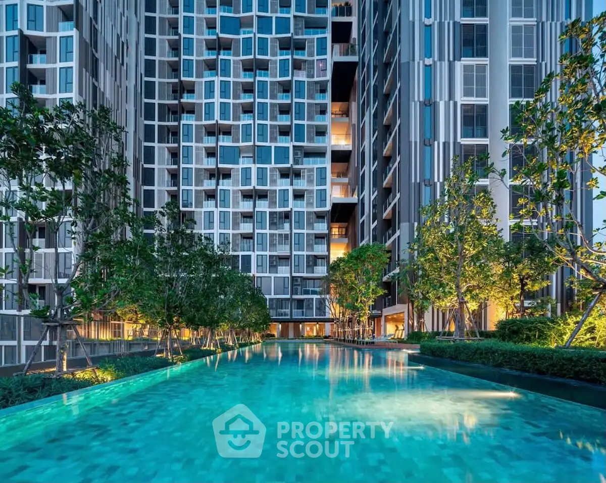 Luxurious modern condominium with stunning illuminated pool and lush greenery, perfect for urban living.