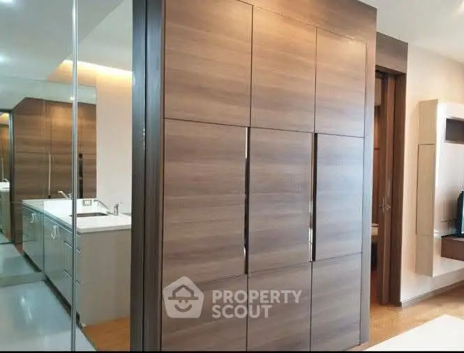 Modern bathroom with sleek wooden cabinetry and mirrored walls