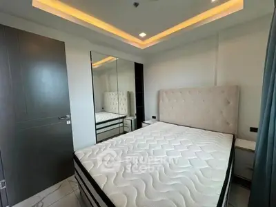 Modern bedroom with stylish lighting and plush headboard in a sleek apartment.