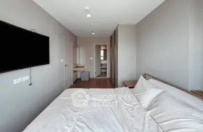 Modern bedroom with minimalist decor and wall-mounted TV