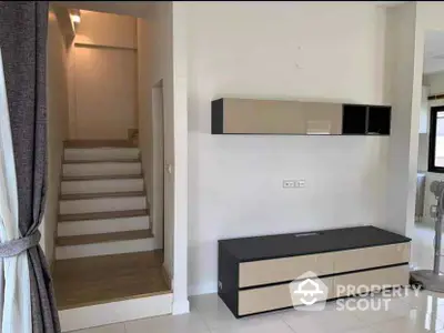 Modern interior with sleek storage unit and staircase in contemporary home