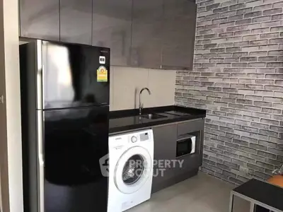 Modern kitchen with sleek appliances and stylish brick wall design.