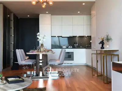 Modern open-layout kitchen and dining area with sleek design and wooden flooring.