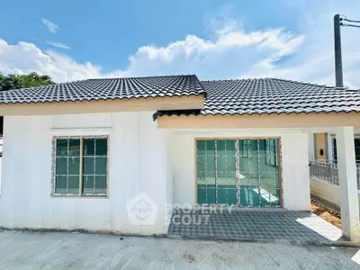 Charming single-story home with tiled roof and large windows, perfect for natural light lovers.