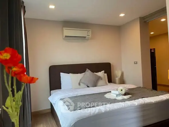 Modern bedroom with cozy bed, air conditioning, and elegant decor in a stylish apartment.