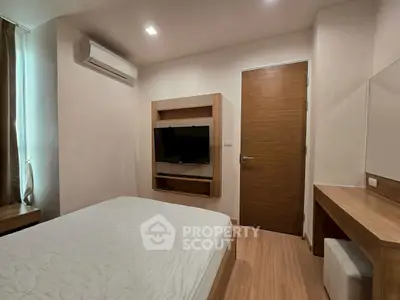 Modern bedroom with sleek wooden furniture and wall-mounted TV, perfect for cozy living.