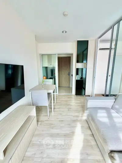 Modern living room with sleek furniture and wooden flooring in a bright apartment