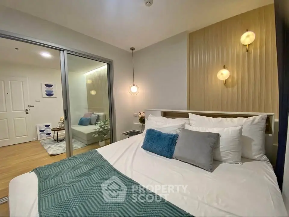 Modern bedroom with stylish decor and glass partition leading to a cozy living area.