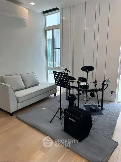 Modern living room with drum set and cozy sofa, perfect for music enthusiasts.