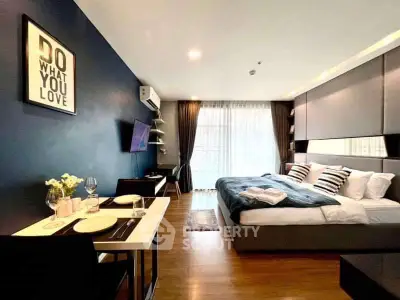 Modern studio apartment with stylish decor and cozy ambiance, featuring a comfortable bed and dining area.