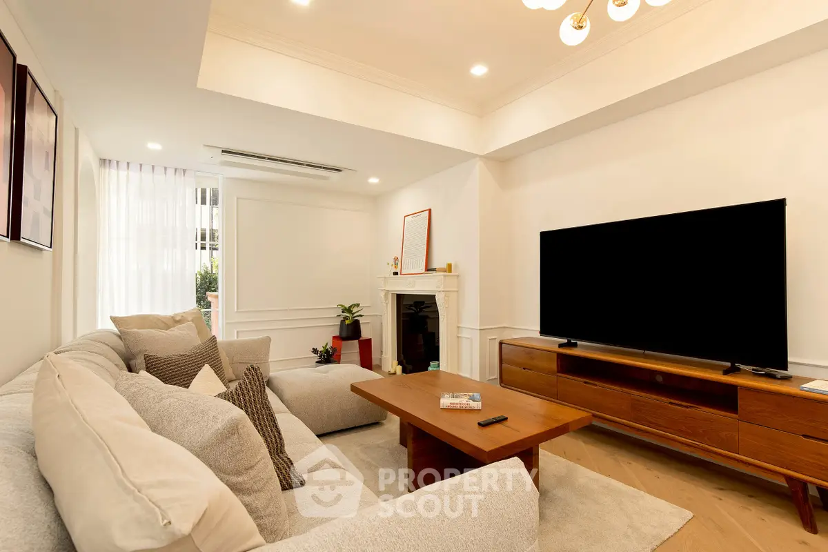 Spacious living room with modern decor, large TV, and cozy seating area, perfect for relaxation.