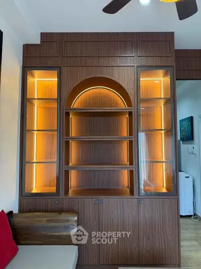 Elegant wooden shelving unit with built-in lighting in a modern living room.