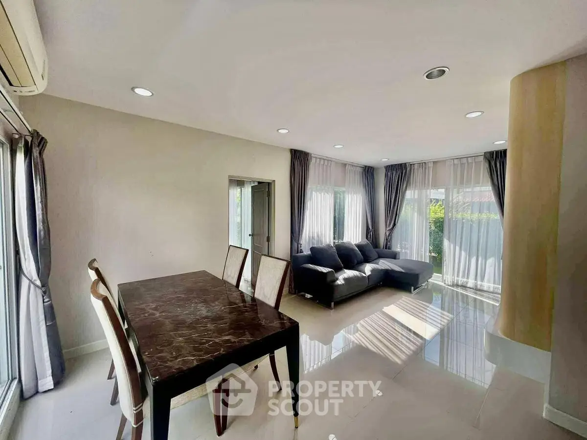 Spacious living room with elegant dining area and large windows